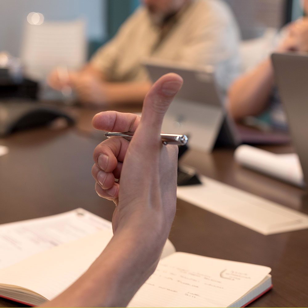 hand with pen on desk